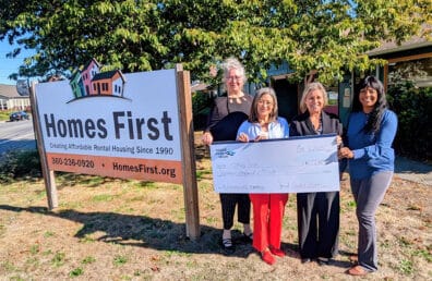 Sound's Community Relations Officers meet with employees of "Homes First" to present a check donation.
